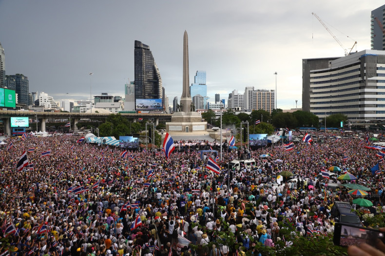 Protesters in Bangkok waving Thai flags and holding signs demanding government accountability after the 2025 Thailand-Cambodia political scandal